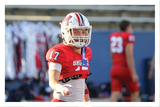 A football player wearing a blue and red jersey. Description generated by AI