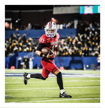 A football player wearing a blue and red jersey. Description generated by AI