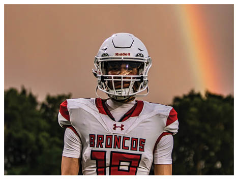 A football player wearing a blue and red jersey. Description generated by AI