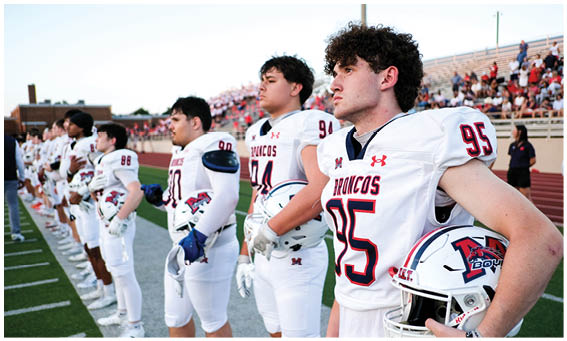 A group of football players on a field. Description generated by AI