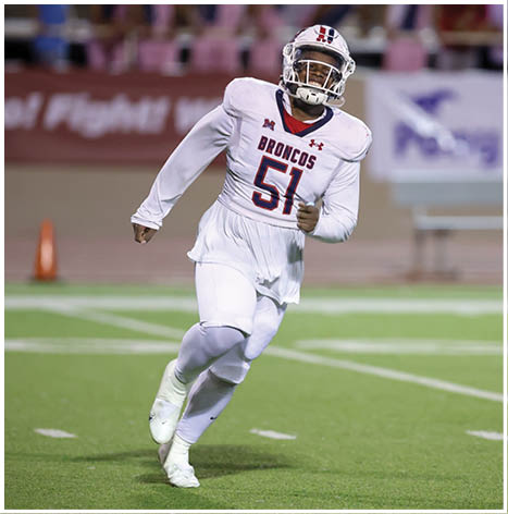 A football player running on the field. Description generated by AI
