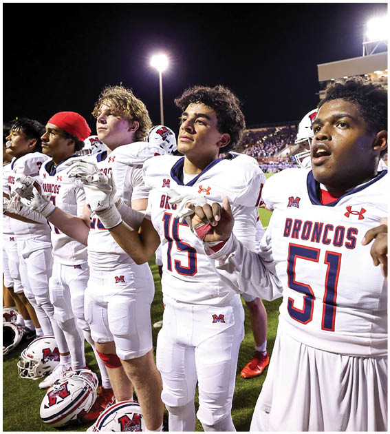 A group of football players wearing black and white uniforms. Description generated by AI