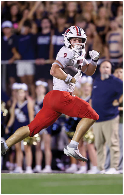 A football player running on the field. Description generated by AI