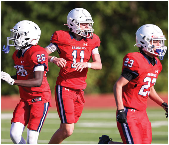 A group of football players wearing black and white uniforms. Description generated by AI