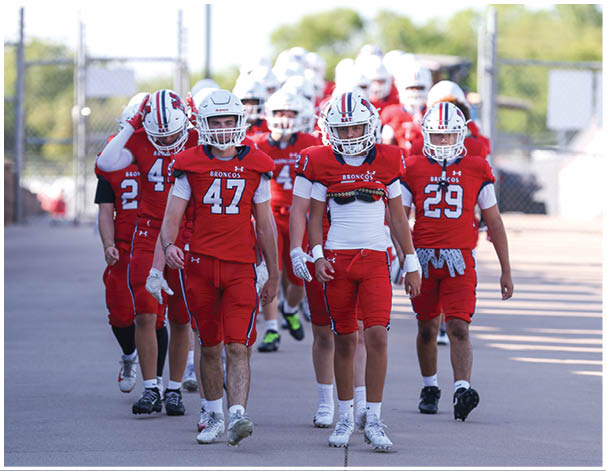 A group of football players wearing black and white uniforms. Description generated by AI