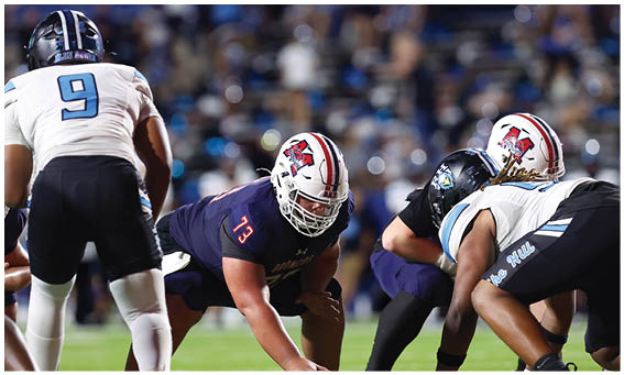 A group of football players on a field. Description generated by AI