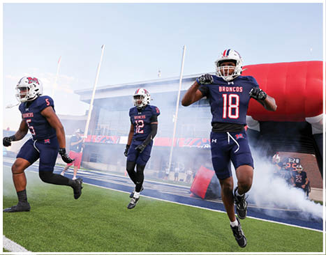 A football player running on the field. Description generated by AI