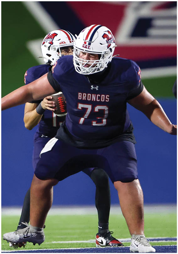 A group of football players wearing black and white uniforms. Description generated by AI