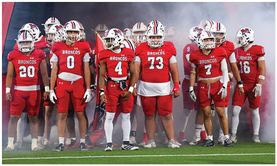 A group of football players on a field. Description generated by AI