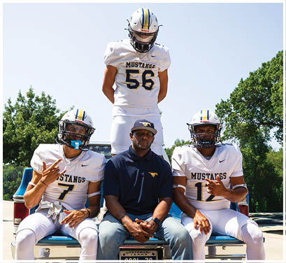 A group of football players huddled together on the field. Description generated by AI