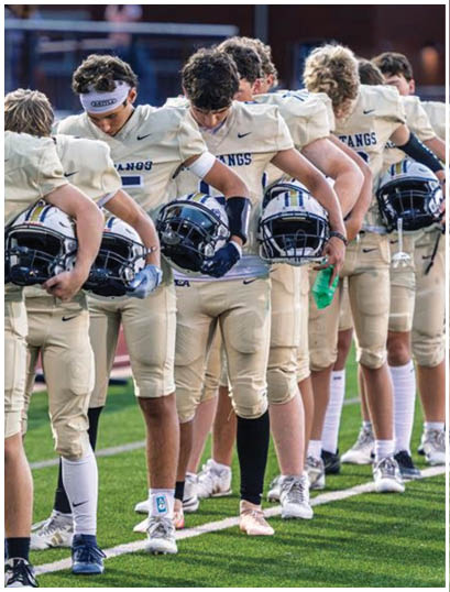 A football player wearing a blue and white uniform. Description generated by AI