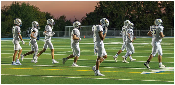 A group of football players on a field. Description generated by AI