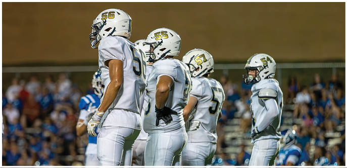 A group of football players on a field. Description generated by AI