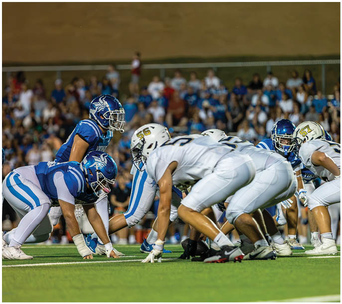 A group of football players on a field. Description generated by AI