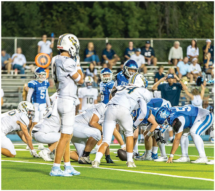 A group of football players on a field. Description generated by AI