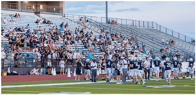 A group of football players on a field. Description generated by AI