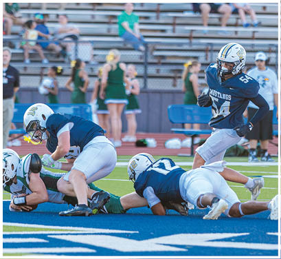 A group of football players huddled together on the field. Description generated by AI
