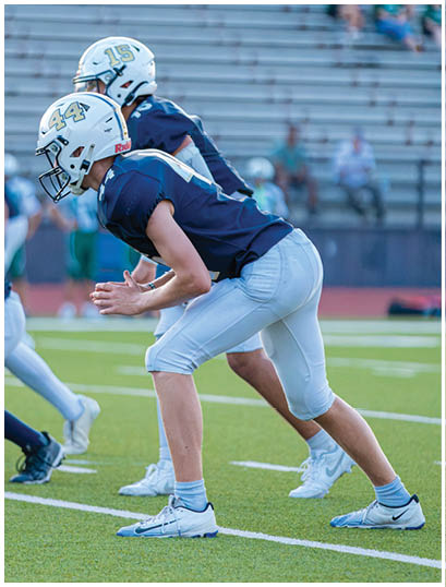 A football player wearing a blue and white uniform. Description generated by AI