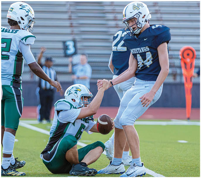 A group of football players on a field. Description generated by AI