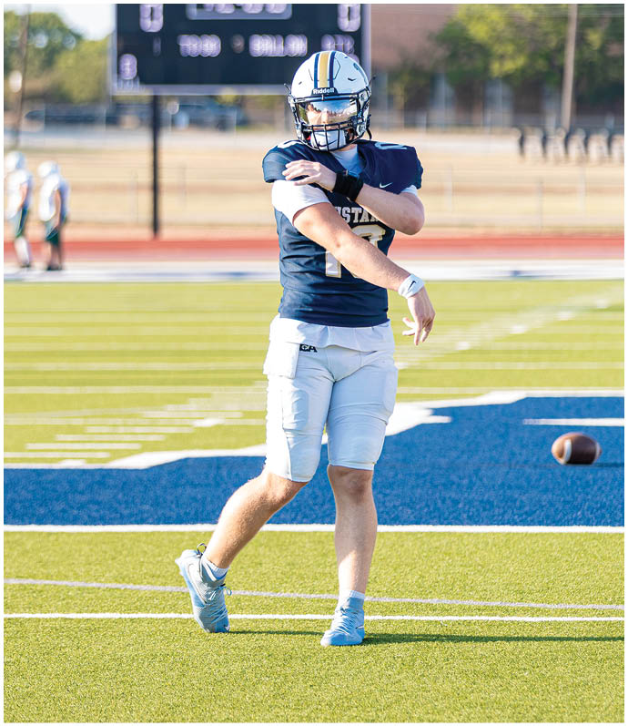 Three football players in blue and white uniforms running on a field. Description generated by AI