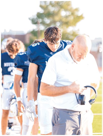 A football player wearing a blue and white uniform. Description generated by AI