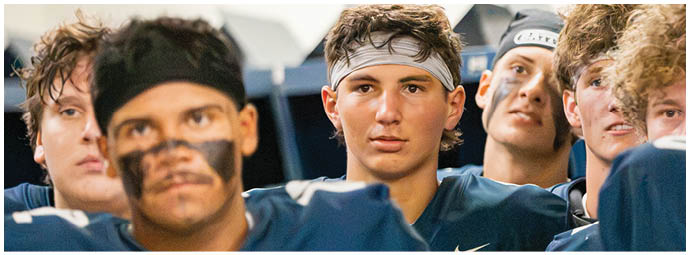 A football player wearing a blue and white uniform. Description generated by AI