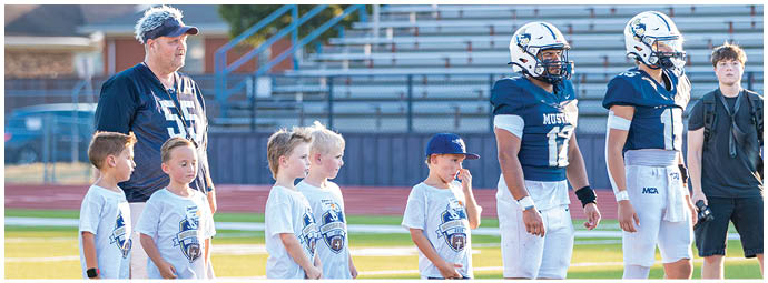 A football player wearing a blue and white uniform. Description generated by AI