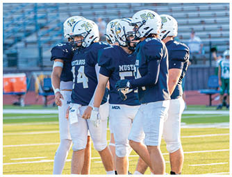 A group of football players on a field. Description generated by AI