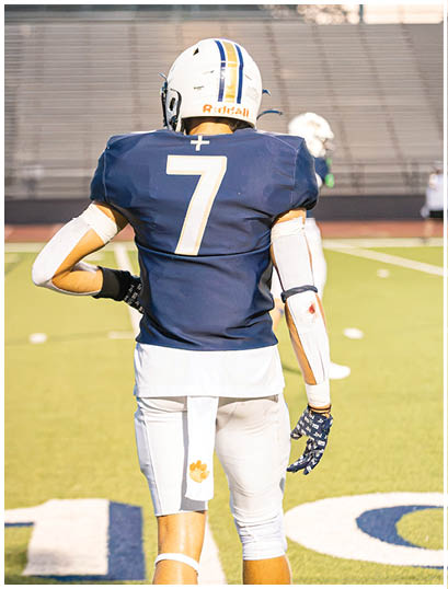 A football player wearing a blue and white uniform. Description generated by AI