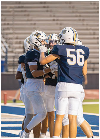 A group of football players wearing black and white uniforms. Description generated by AI