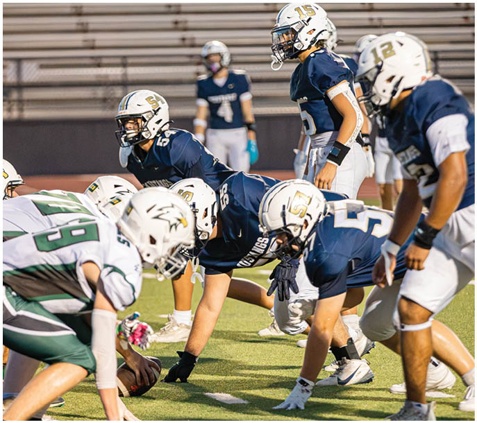 A group of football players on a field. Description generated by AI