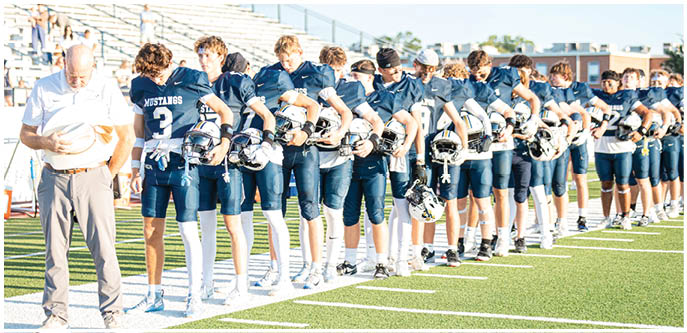 A group of football players on a field. Description generated by AI
