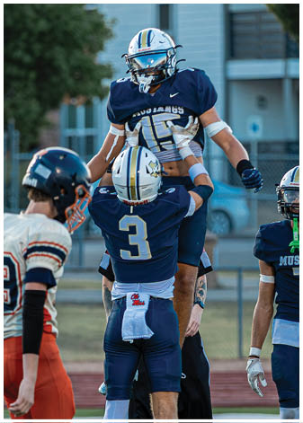 A group of football players wearing black and white uniforms. Description generated by AI