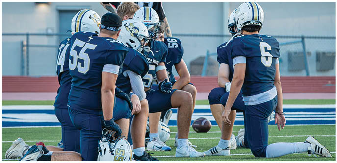 A group of football players on a field. Description generated by AI