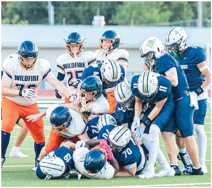 A group of football players on a field. Description generated by AI