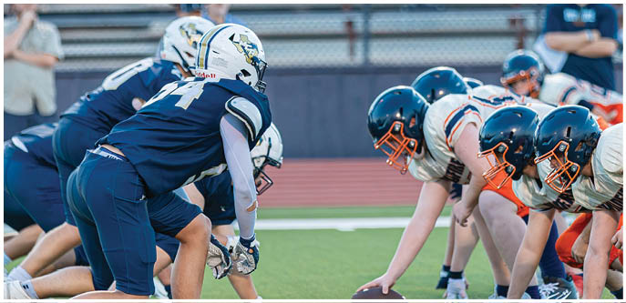 A group of football players on a field. Description generated by AI