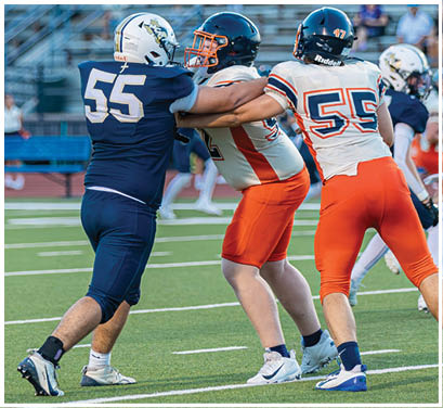 A group of football players huddled together on the field. Description generated by AI