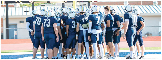 A football player wearing a blue and white uniform. Description generated by AI