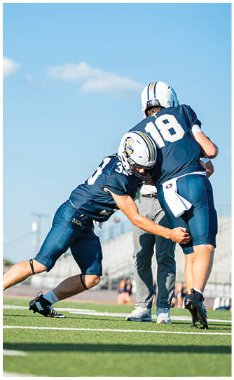 A football player catching a ball. Description generated by AI