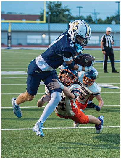 A football player wearing a blue and white uniform. Description generated by AI