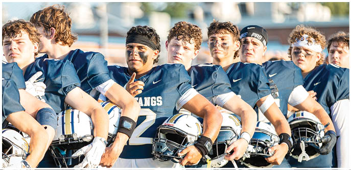 A group of football players on a field. Description generated by AI