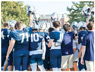 A group of football players on a field. Description generated by AI