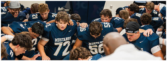 A football player wearing a blue and white uniform. Description generated by AI