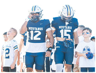 A group of football players on a field. Description generated by AI