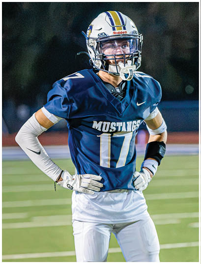 A football player wearing a blue and white uniform. Description generated by AI