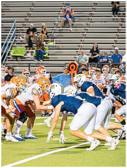 A football player wearing a blue and white uniform. Description generated by AI