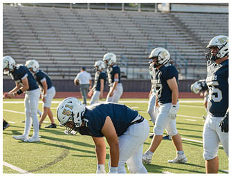 A group of football players on a field. Description generated by AI
