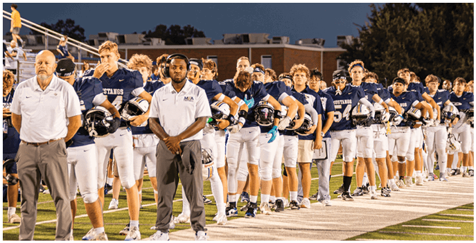 A group of football players on a field. Description generated by AI
