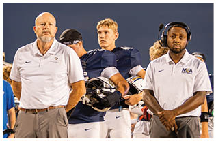 A group of football players on a field. Description generated by AI