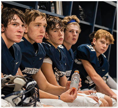 A group of football players huddled together on the field. Description generated by AI